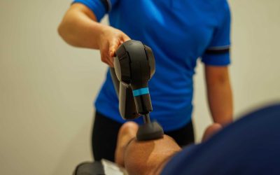 Kinetic Sports Performance staff using a massage gun